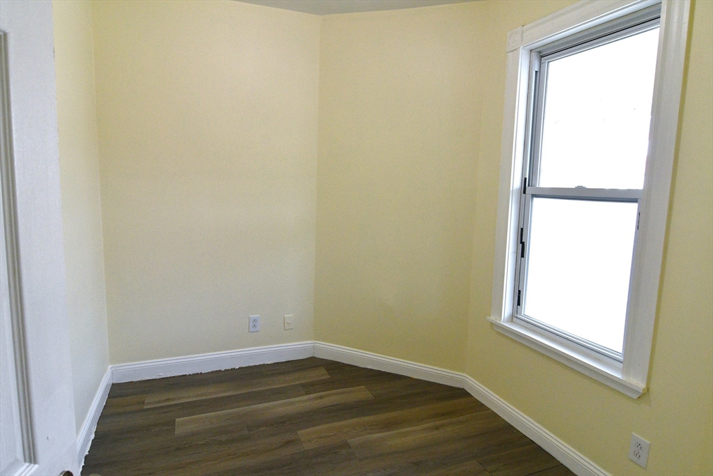 121 Cottage Street Everett, MA 02149 - Photo 27 of 35 a view of an empty room with wooden floor and a window