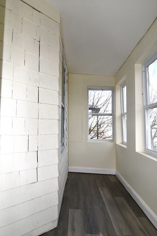 121 Cottage Street Everett, MA 02149 - Photo 28 of 35 an empty room with wooden floor and windows