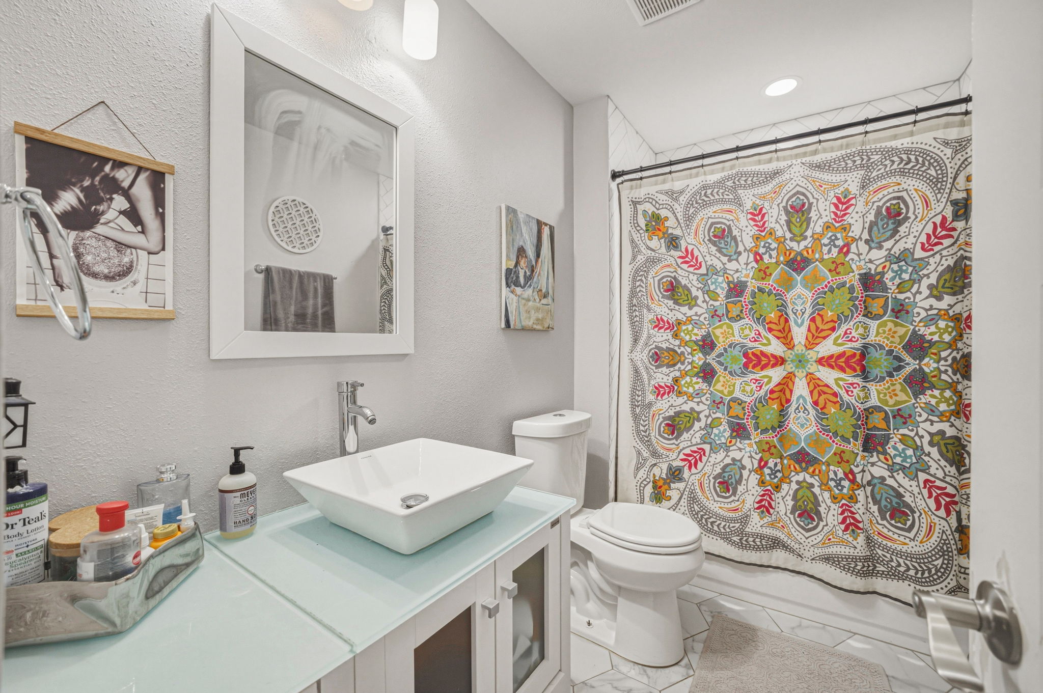 5332 Balcones Drive, Unit B Austin, TX 78731 - Photo 14 of 15 The bathroom features a vessel sink, a vanity with a light-colored countertop, and a shower with a decorative curtain