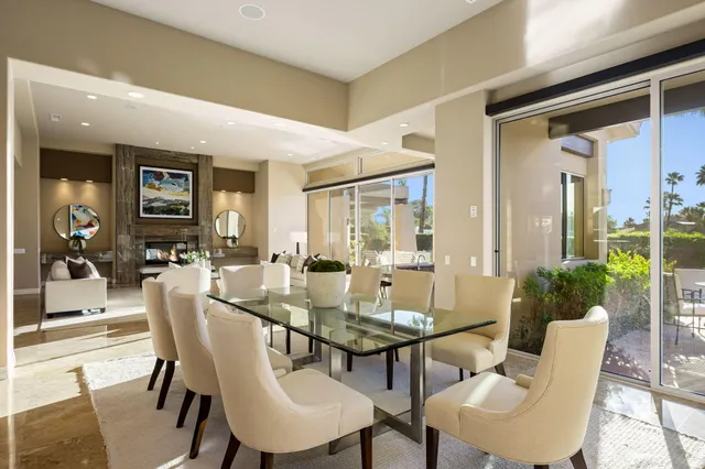 a dining room with stainless steel appliances granite countertop a stove a kitchen island a table and chairs