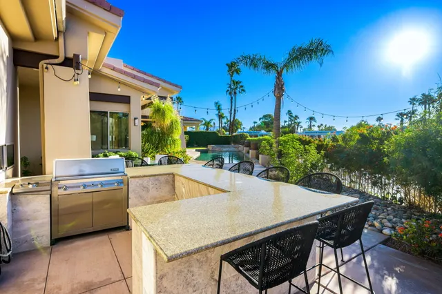 a patio with table and chairs and potted plants