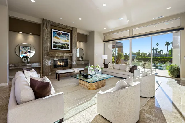 a living room with fireplace furniture and a large window