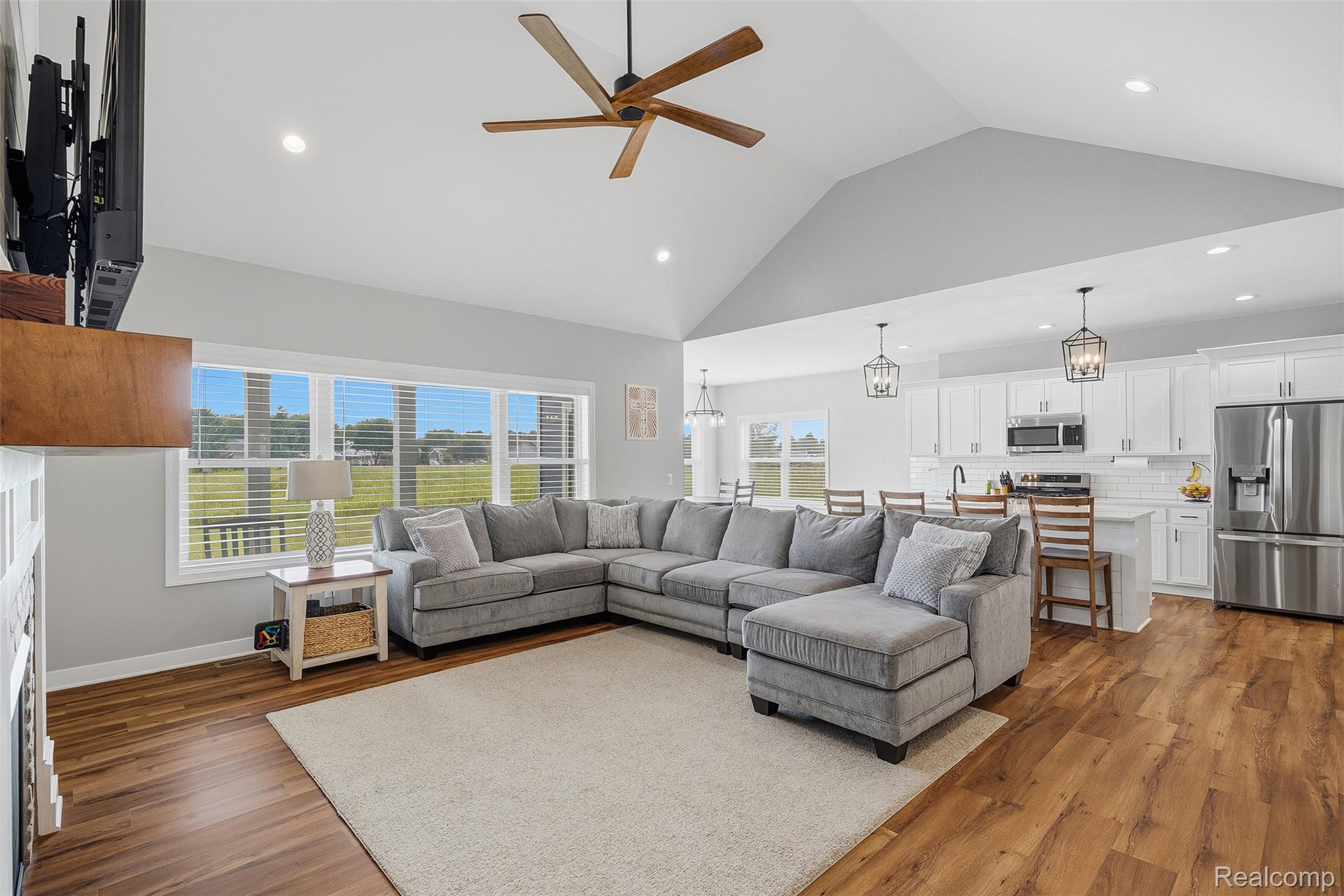9087 Copper Ridge Drive Davison, MI 48423 - Photo 17 of 46 Vaulted ceiling living area featuring wood-finish flooring, a contemporary ceiling fan, recessed lighting, and large windows