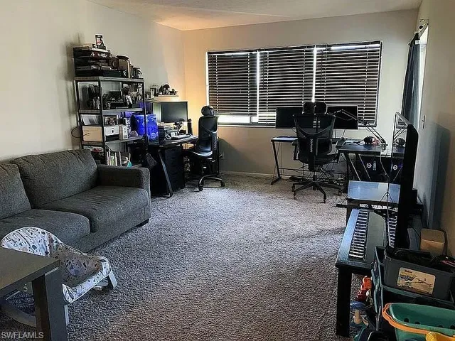 a view of a workspace with furniture and a window