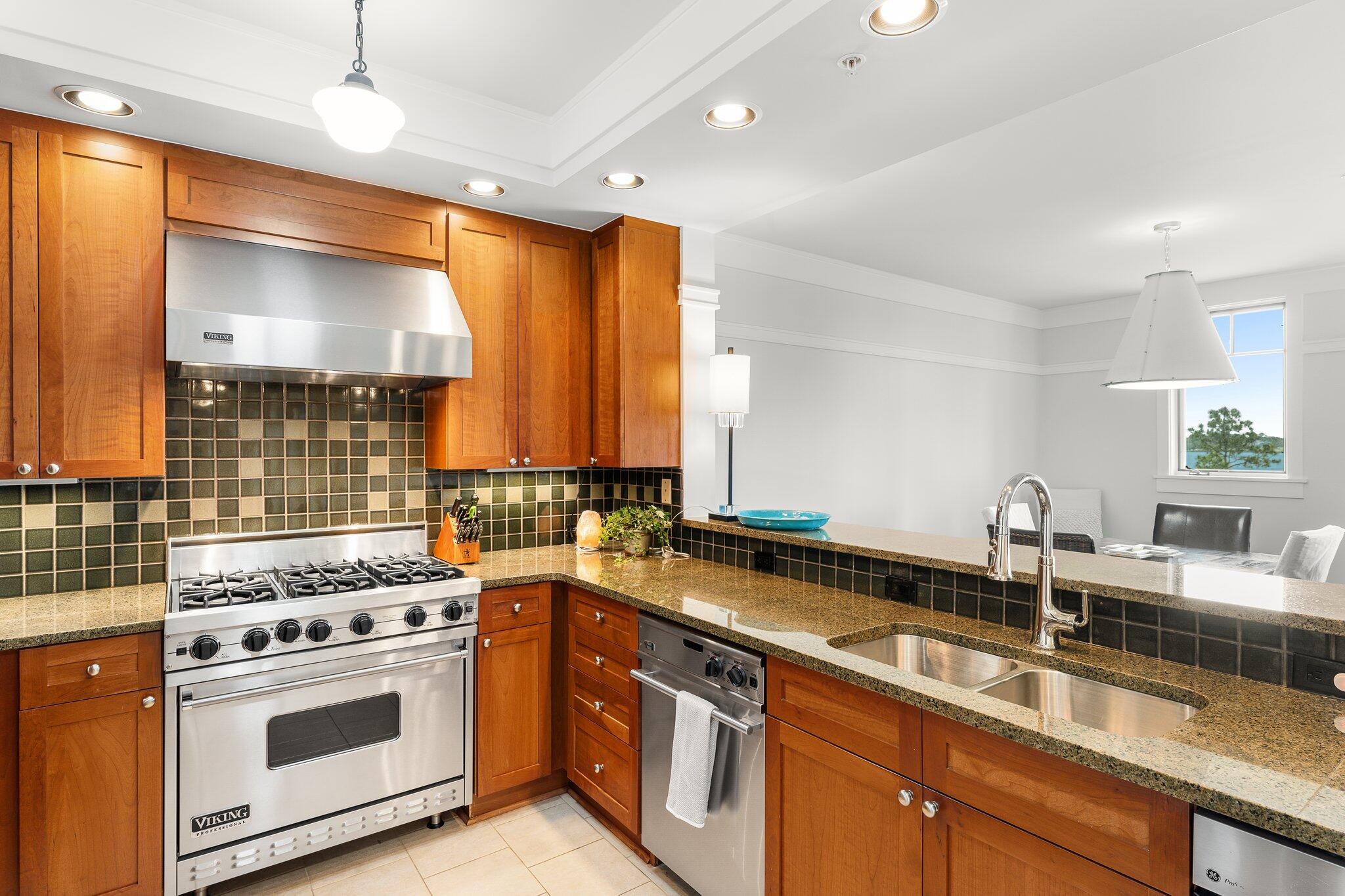 1102 Prospect Promenade, Unit 202 Panama City Beach, FL 32413 - Photo 11 of 35 a kitchen with a sink stove and cabinets