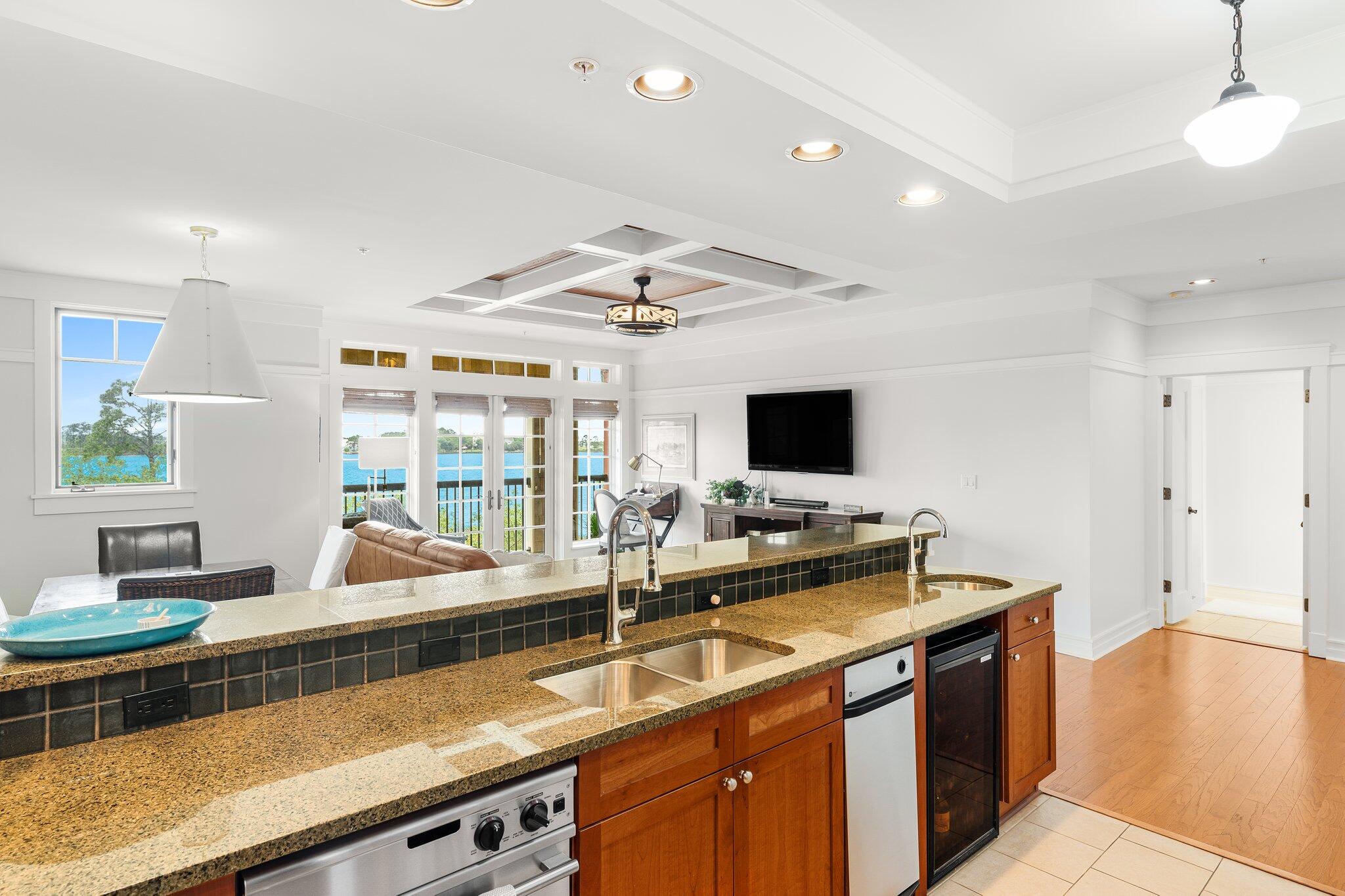1102 Prospect Promenade, Unit 202 Panama City Beach, FL 32413 - Photo 12 of 35 a living room with stainless steel appliances kitchen island granite countertop a sink and cabinets