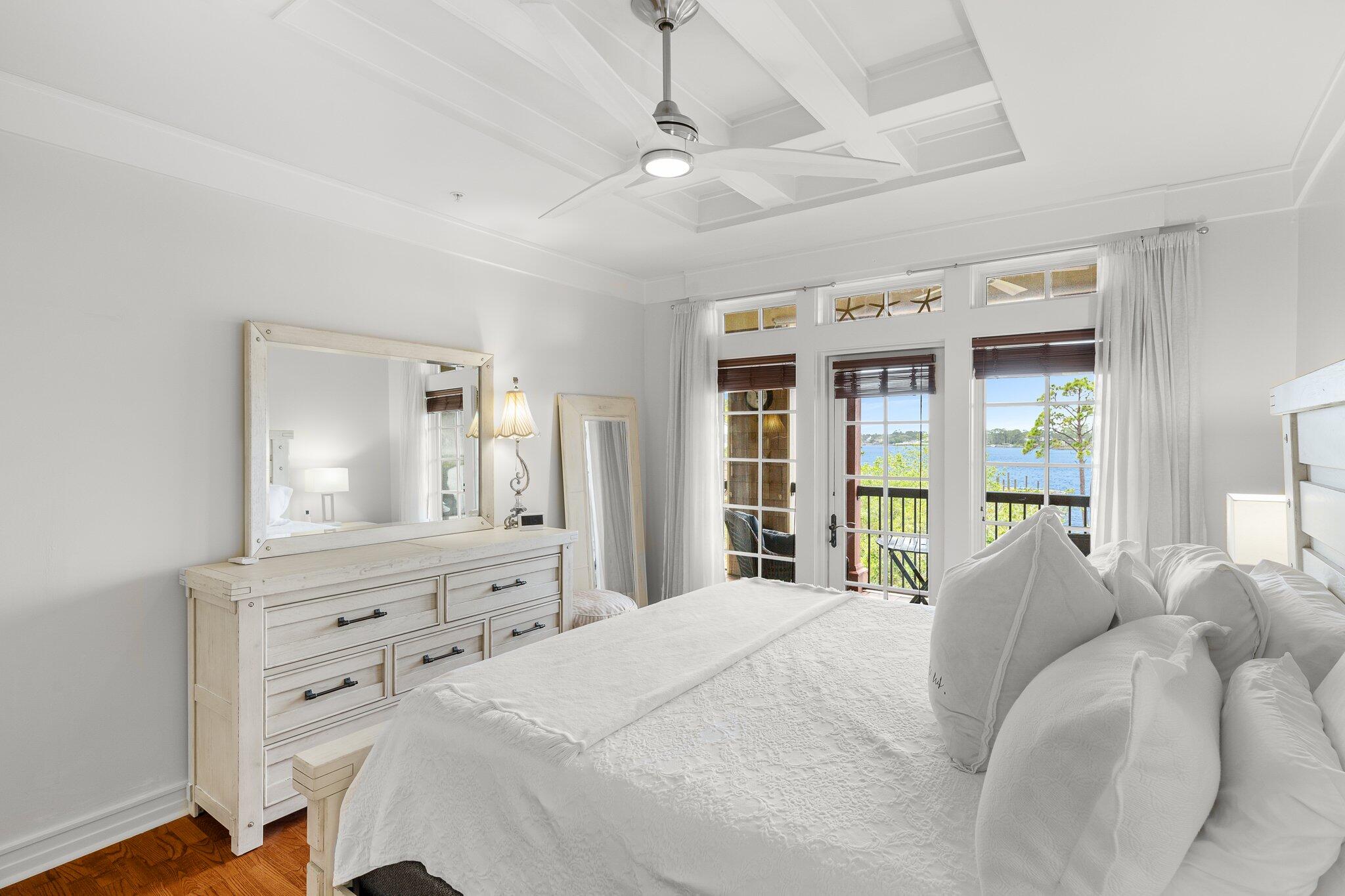 1102 Prospect Promenade, Unit 202 Panama City Beach, FL 32413 - Photo 20 of 35 a bedroom with a bed a large window and mirror