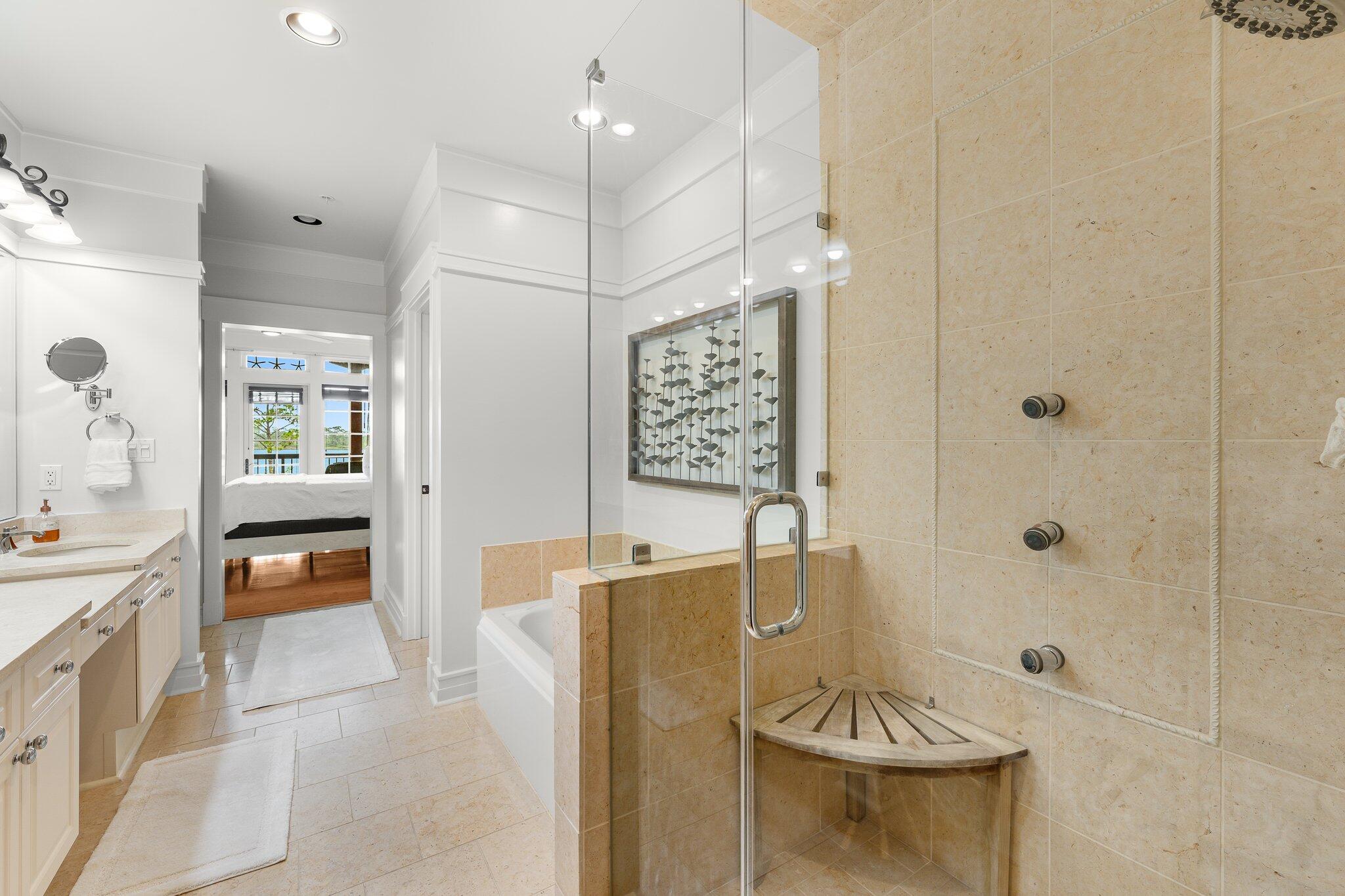 1102 Prospect Promenade, Unit 202 Panama City Beach, FL 32413 - Photo 23 of 35 a spacious bathroom with a granite countertop sink a mirror a bathtub and shower