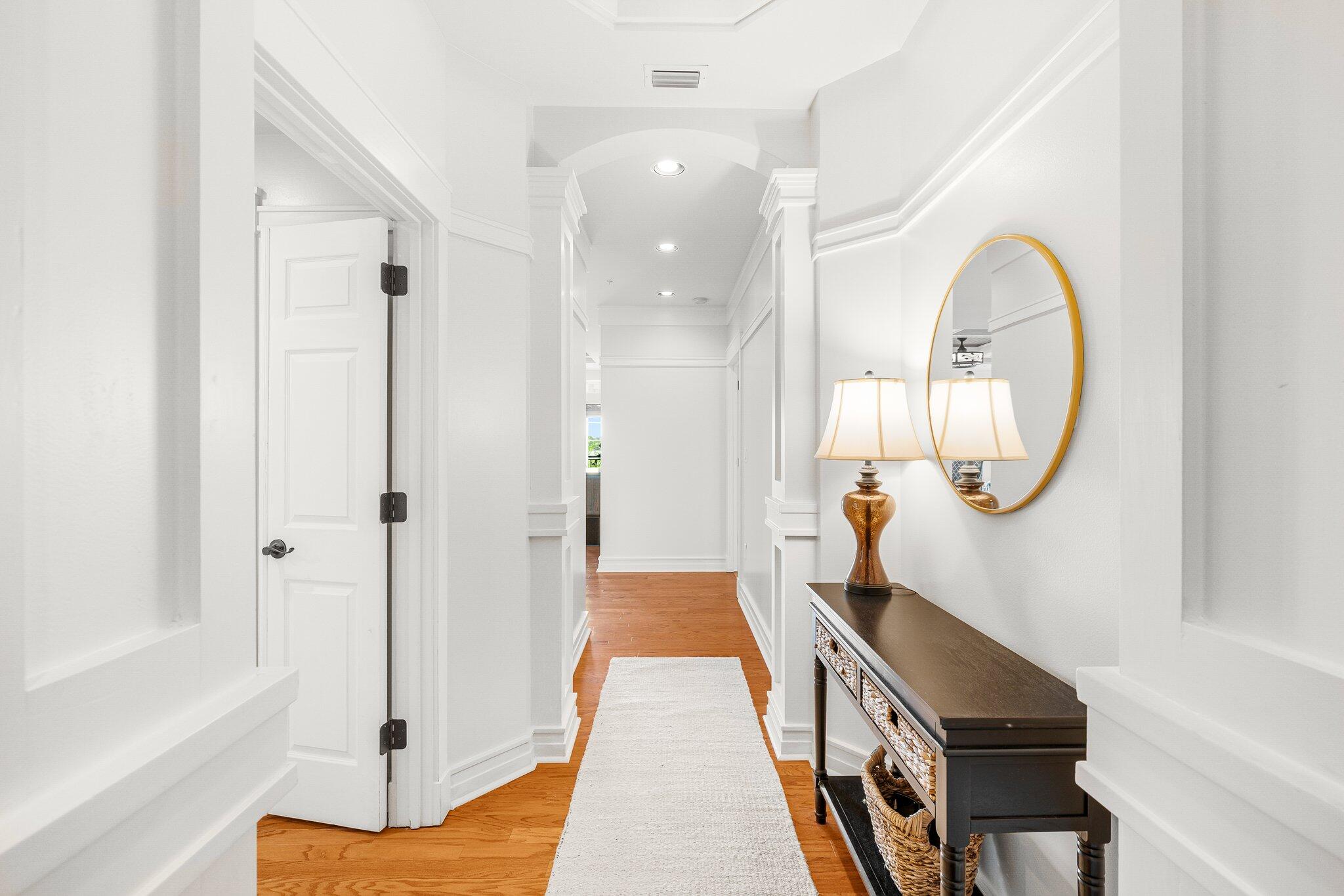 1102 Prospect Promenade, Unit 202 Panama City Beach, FL 32413 - Photo 8 of 35 a view of a hallway with entryway wooden floor and front door