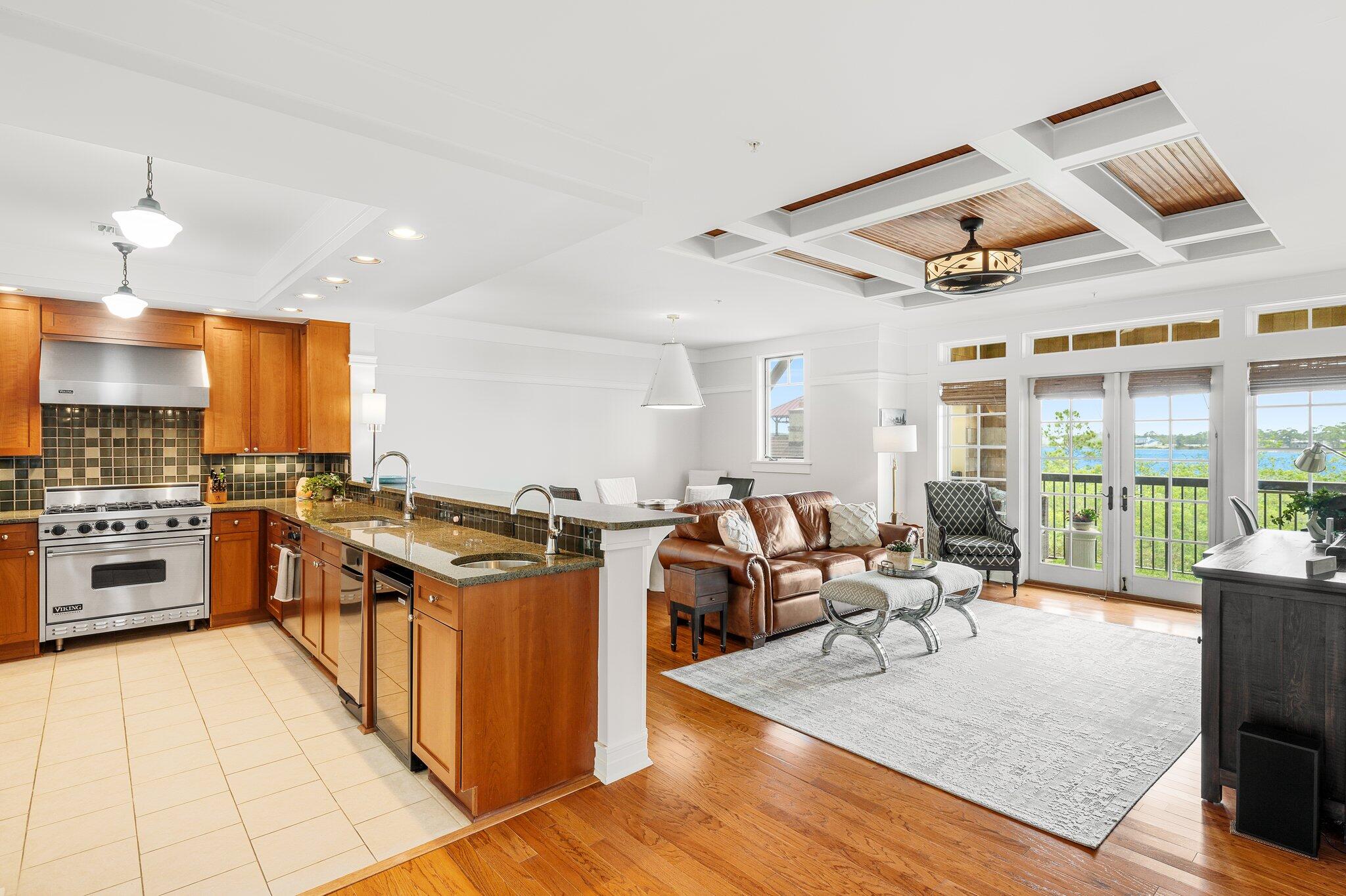 1102 Prospect Promenade, Unit 202 Panama City Beach, FL 32413 - Photo 9 of 35 a kitchen with stainless steel appliances granite countertop a stove oven and a dining table with granite countertops