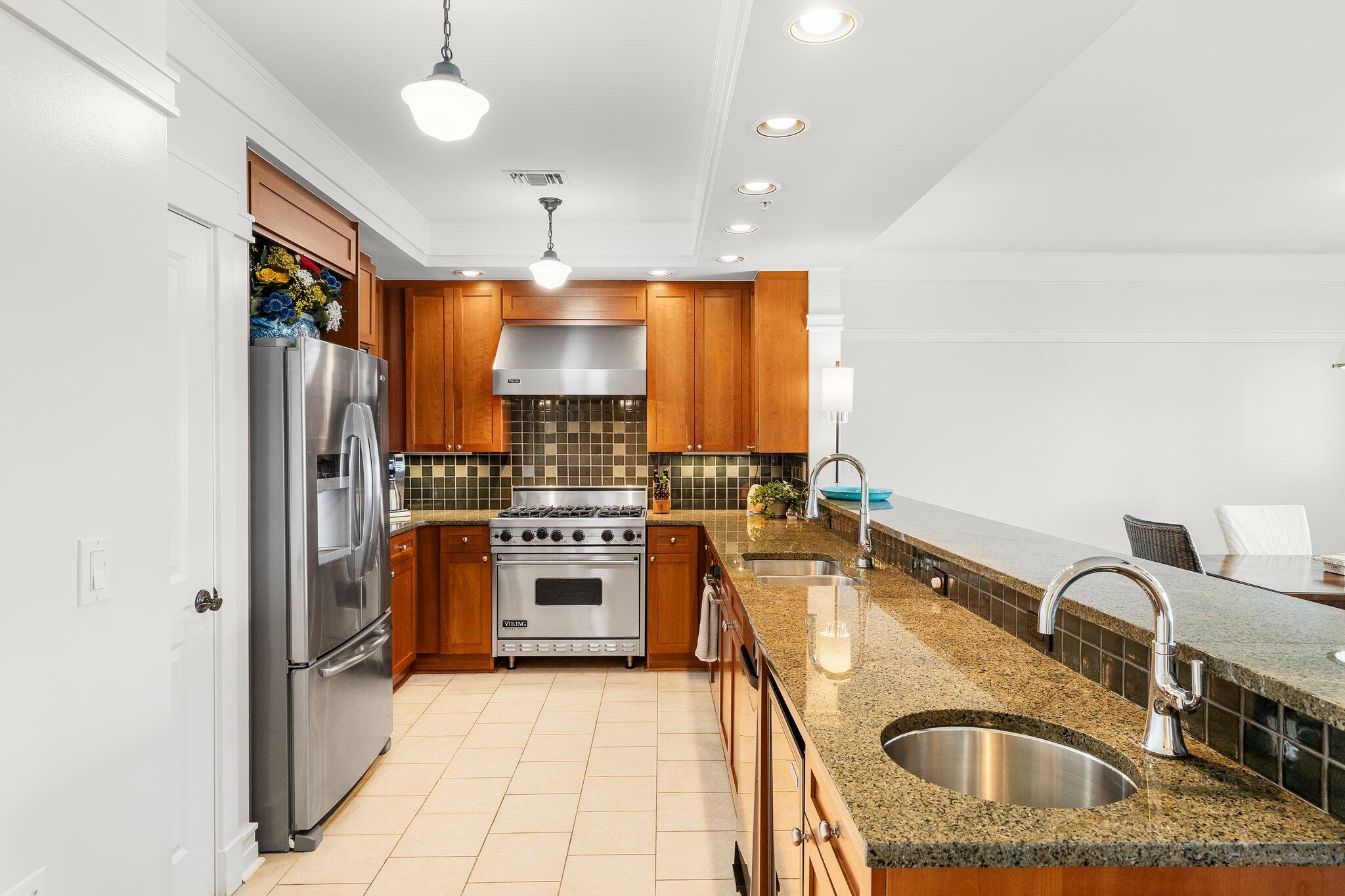 1102 Prospect Promenade, Unit 202 Panama City Beach, FL 32413 - Photo 10 of 35 a kitchen with stainless steel appliances granite countertop a sink a stove and refrigerator