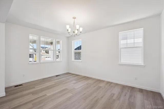 a view of empty room with wooden floor and window