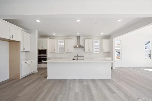 a view of kitchen with stainless steel appliances refrigerator stove microwave and cabinets