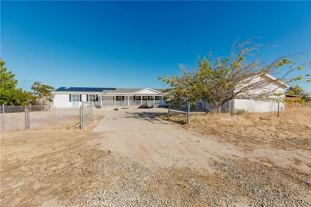 a view of a livingroom with a fireplace a ceiling fan and windows