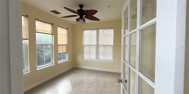 a view of a room a chandelier fan and entryway