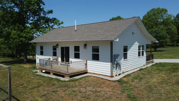 a view of house that has a bed and wooden fence