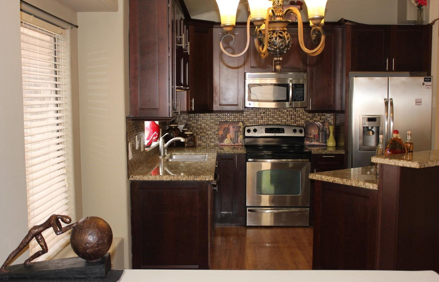 9456 East Pine Valley Road Scottsdale, AZ 85260 - Photo 14 of 18 a kitchen with stainless steel appliances granite countertop a stove and a wooden floor