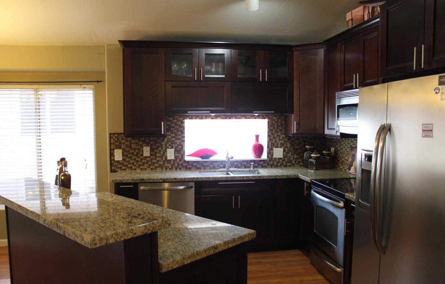 9456 East Pine Valley Road Scottsdale, AZ 85260 - Photo 7 of 18 a kitchen with stainless steel appliances granite countertop a sink stove and refrigerator