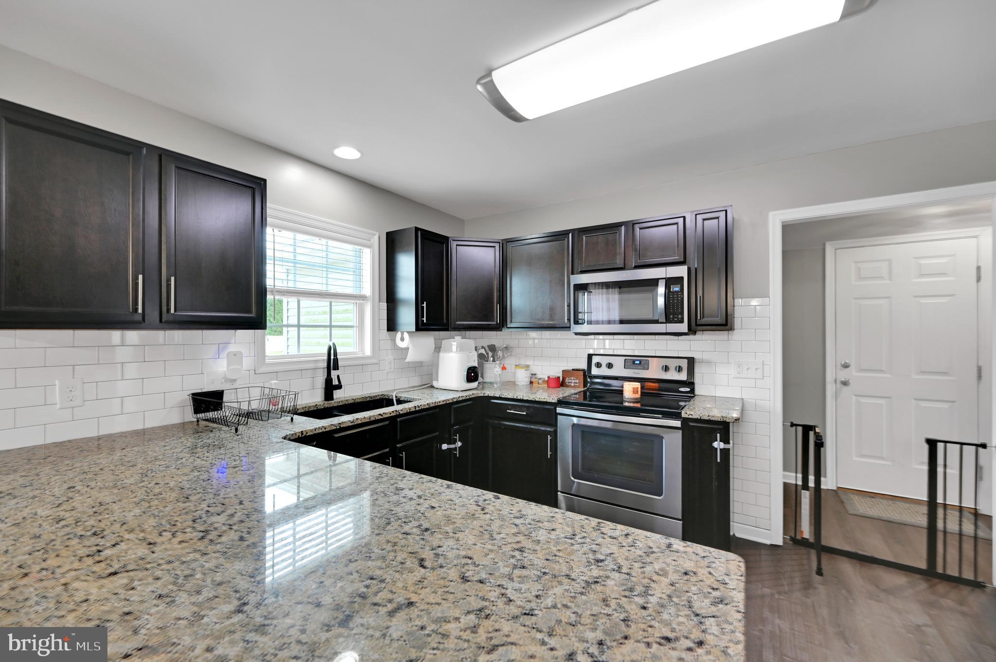 36809 Red Berry Road Delmar, DE 19940 - Photo 3 of 19 a kitchen with granite countertop a sink and steel appliances
