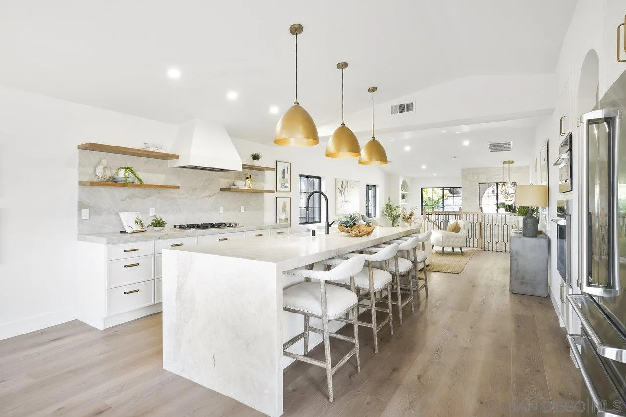8843 Mariposa Street La Mesa, CA 91941 - Photo 12 of 60 a kitchen with stainless steel appliances kitchen island granite countertop a table chairs and a chandelier
