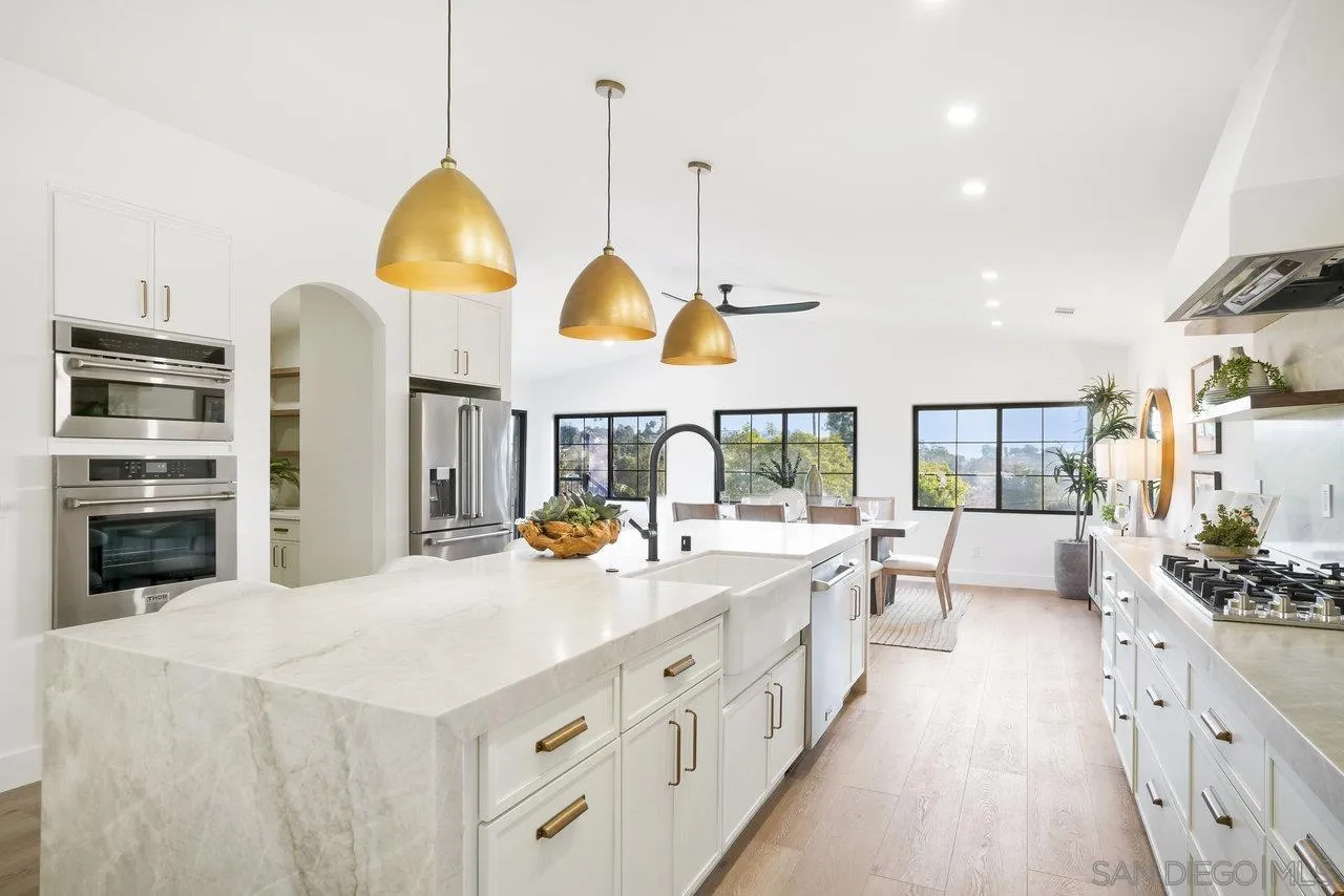 8843 Mariposa Street La Mesa, CA 91941 - Photo 13 of 60 a kitchen with stainless steel appliances a sink a stove and a chandelier