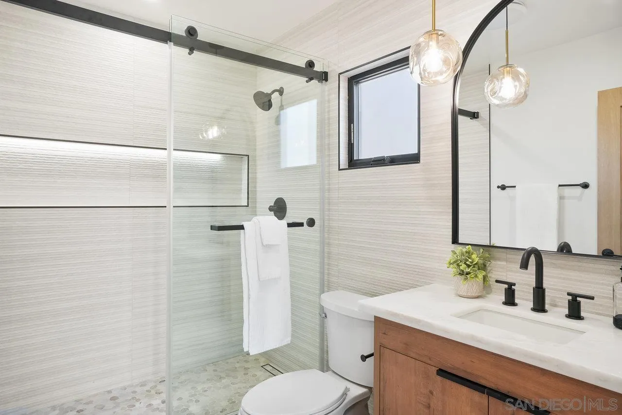 8843 Mariposa Street La Mesa, CA 91941 - Photo 28 of 60 a bathroom with a sink vanity granite toilet and shower