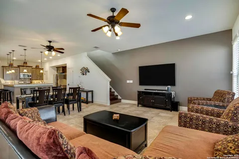a living room with furniture kitchen view and a flat screen tv