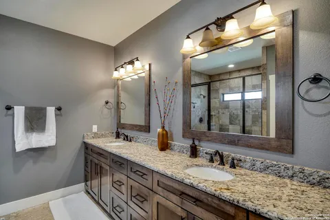 a bathroom with a granite countertop sink and a mirror
