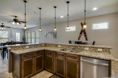 a kitchen with a sink a stove and a wooden floor