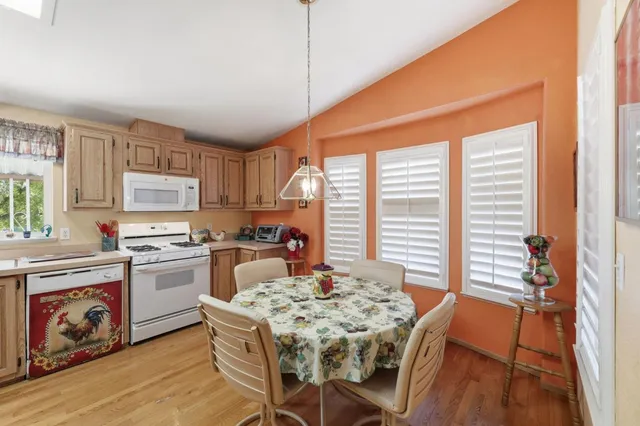 a kitchen with a table chairs stove and refrigerator