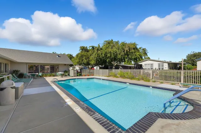 a view of a swimming pool with a patio and a yard