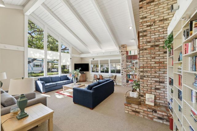 a living room with furniture a flat screen tv and a large window