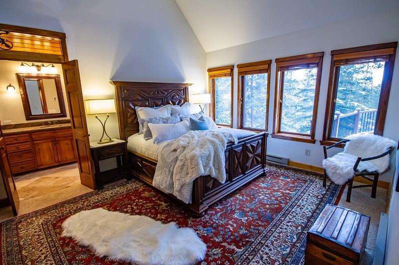 37 Wintergreen Circle Keystone, CO 80435 - Photo 11 of 35 a bedroom with a bed a lamp on dresser and a large window