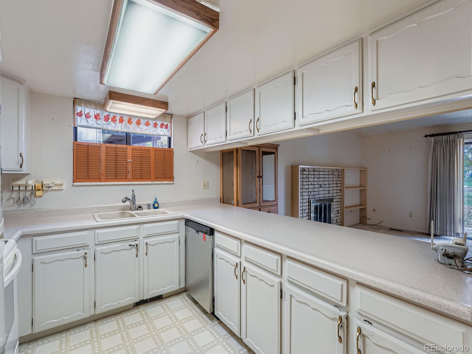 3447 South Norfolk Way Aurora, CO 80013 - Photo 1 of 14 a kitchen with a sink cabinets and window