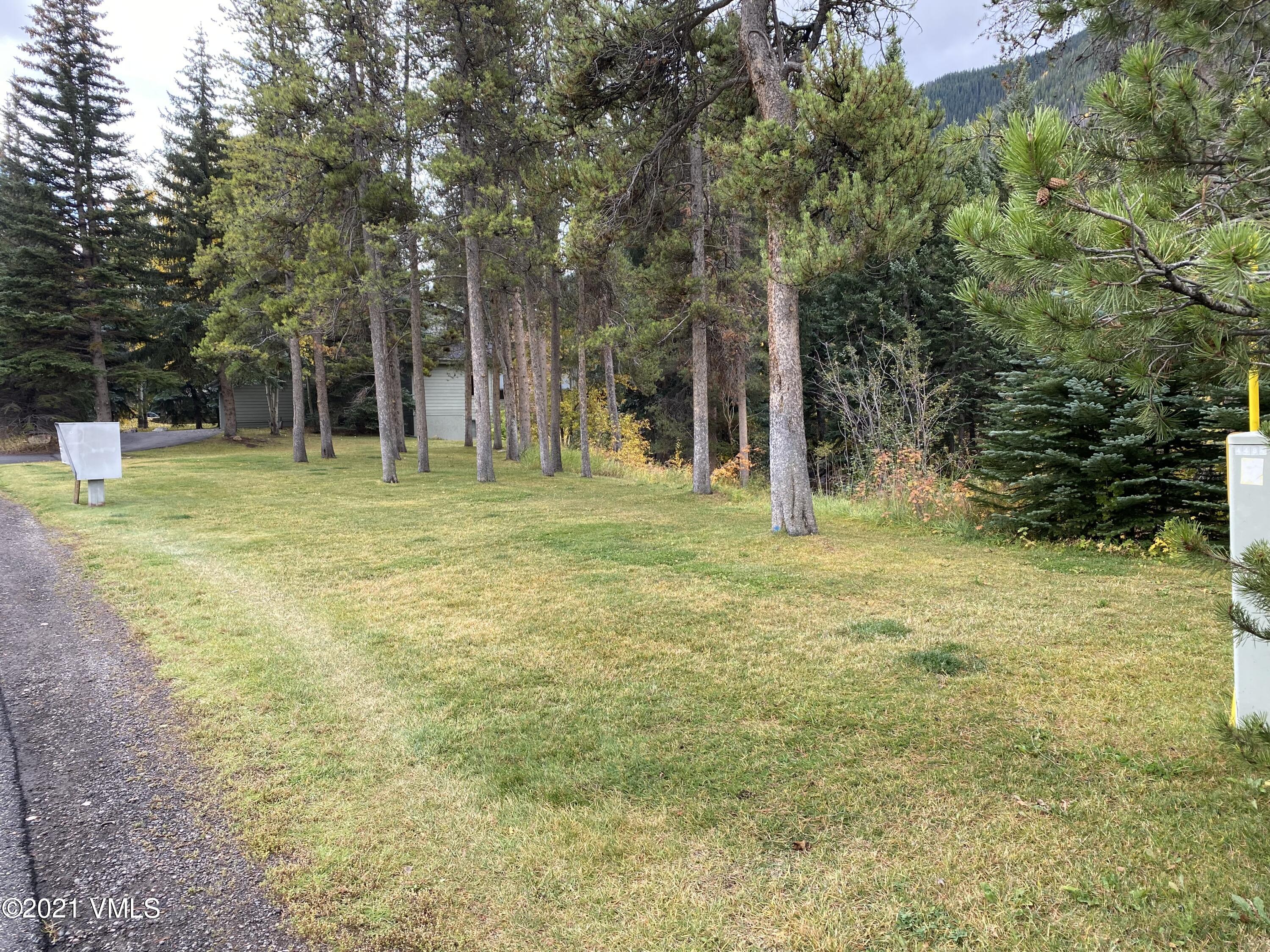 4484 Streamside Circle Vail, CO 81657 - Photo 2 of 29 a backyard of a house with lots of green space and fountain