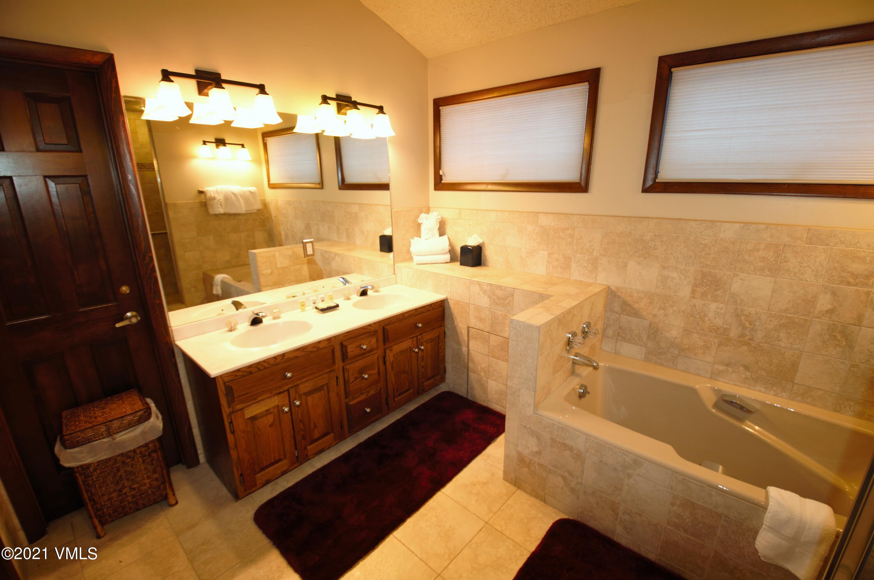 4484 Streamside Circle Vail, CO 81657 - Photo 27 of 29 a bathroom with a tub sink and mirror