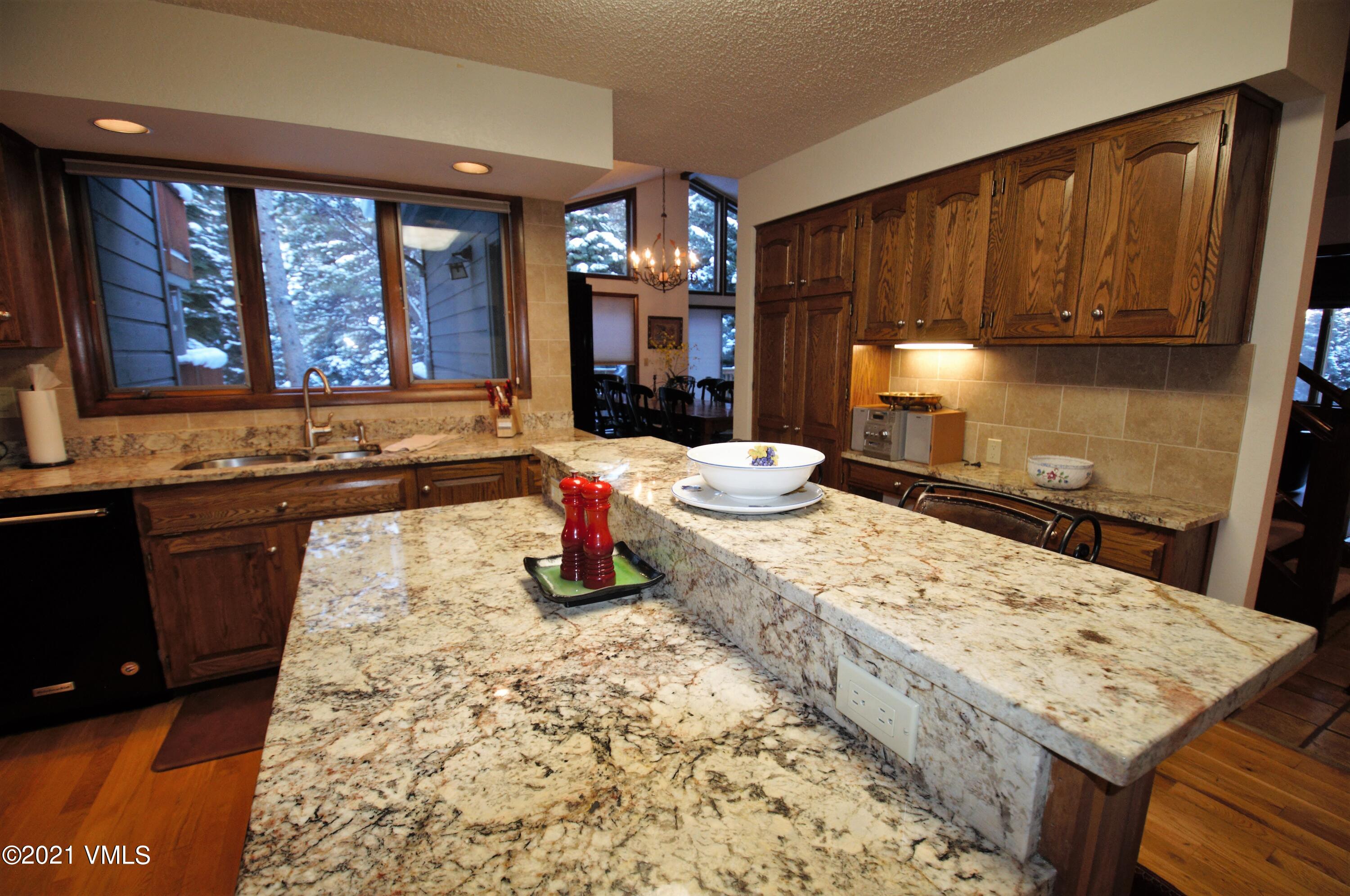 4484 Streamside Circle Vail, CO 81657 - Photo 9 of 29 a kitchen with sink refrigerator dining table and chairs