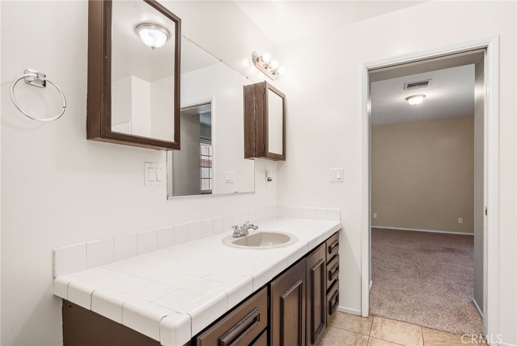 37310 Populus Avenue Palmdale, CA 93552 - Photo 19 of 28 a bathroom with a sink vanity and a mirror