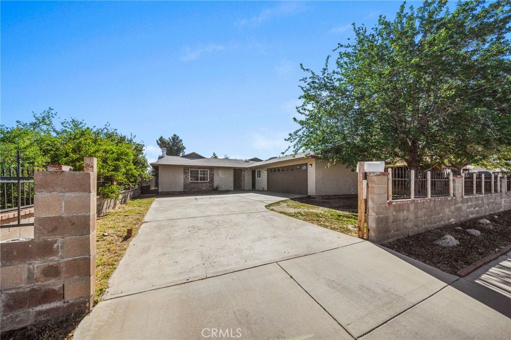 37310 Populus Avenue Palmdale, CA 93552 - Photo 2 of 28 a front view of a house with a yard and garage