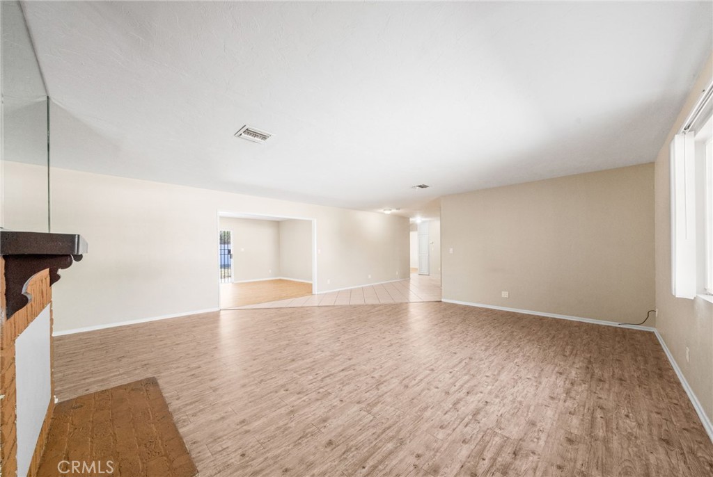 37310 Populus Avenue Palmdale, CA 93552 - Photo 6 of 28 an empty room with wooden floor and windows