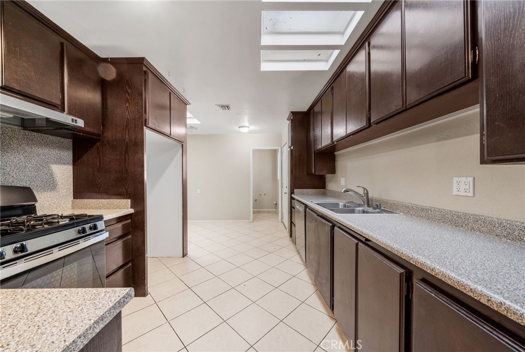 37310 Populus Avenue Palmdale, CA 93552 - Photo 9 of 28 a kitchen with stainless steel appliances granite countertop a sink a stove and a refrigerator