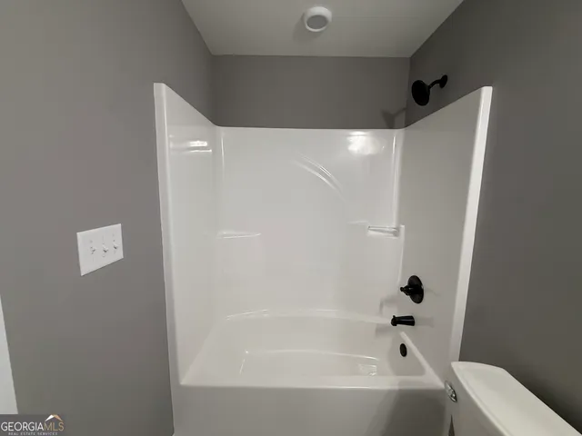 a view of empty room with wooden floor and fireplace