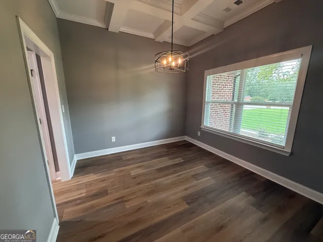 a view of empty room with wooden floor and fireplace