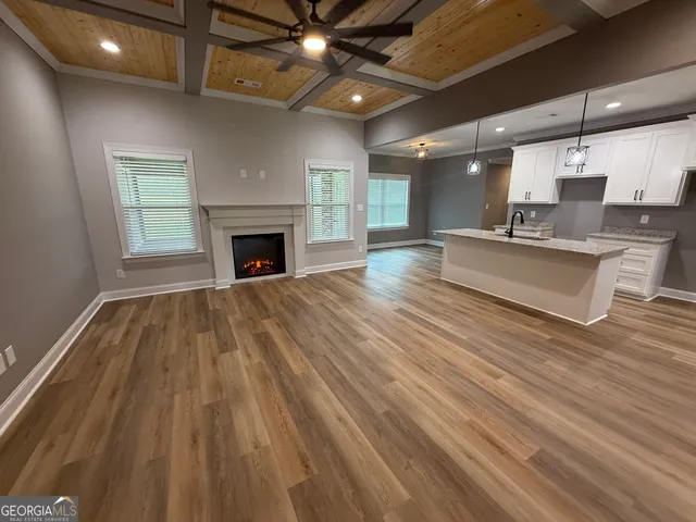 a kitchen with stainless steel appliances granite countertop a sink a stove and a wooden floors