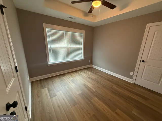a view of empty room with wooden floor