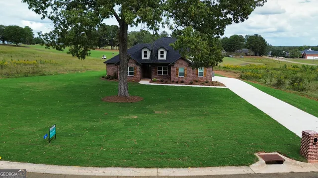 a aerial view of a house next to a big yard with large trees