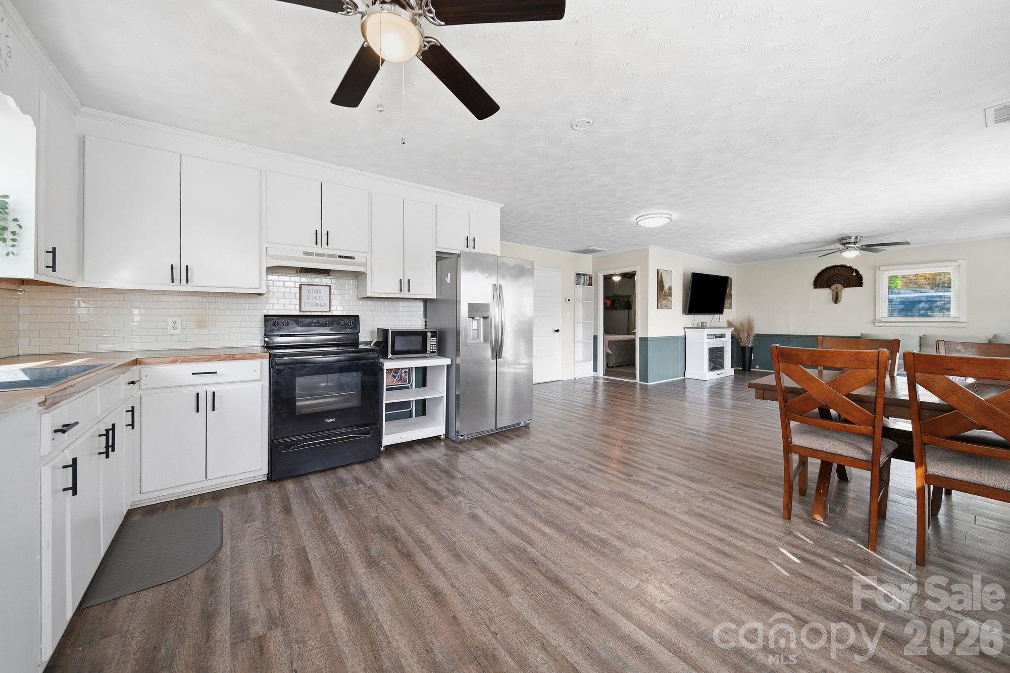 197 Vineyard Road Norwood, NC 28128 - Photo 11 of 27 a kitchen with stainless steel appliances a refrigerator and wooden floor