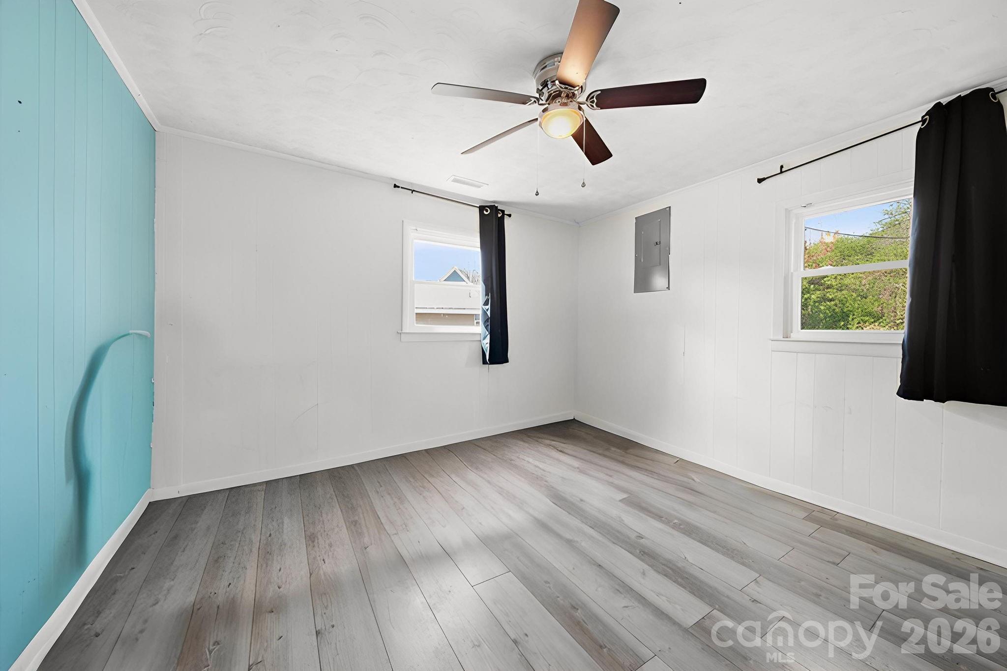 197 Vineyard Road Norwood, NC 28128 - Photo 19 of 27 a view of a livingroom with wooden floor a ceiling fan and windows