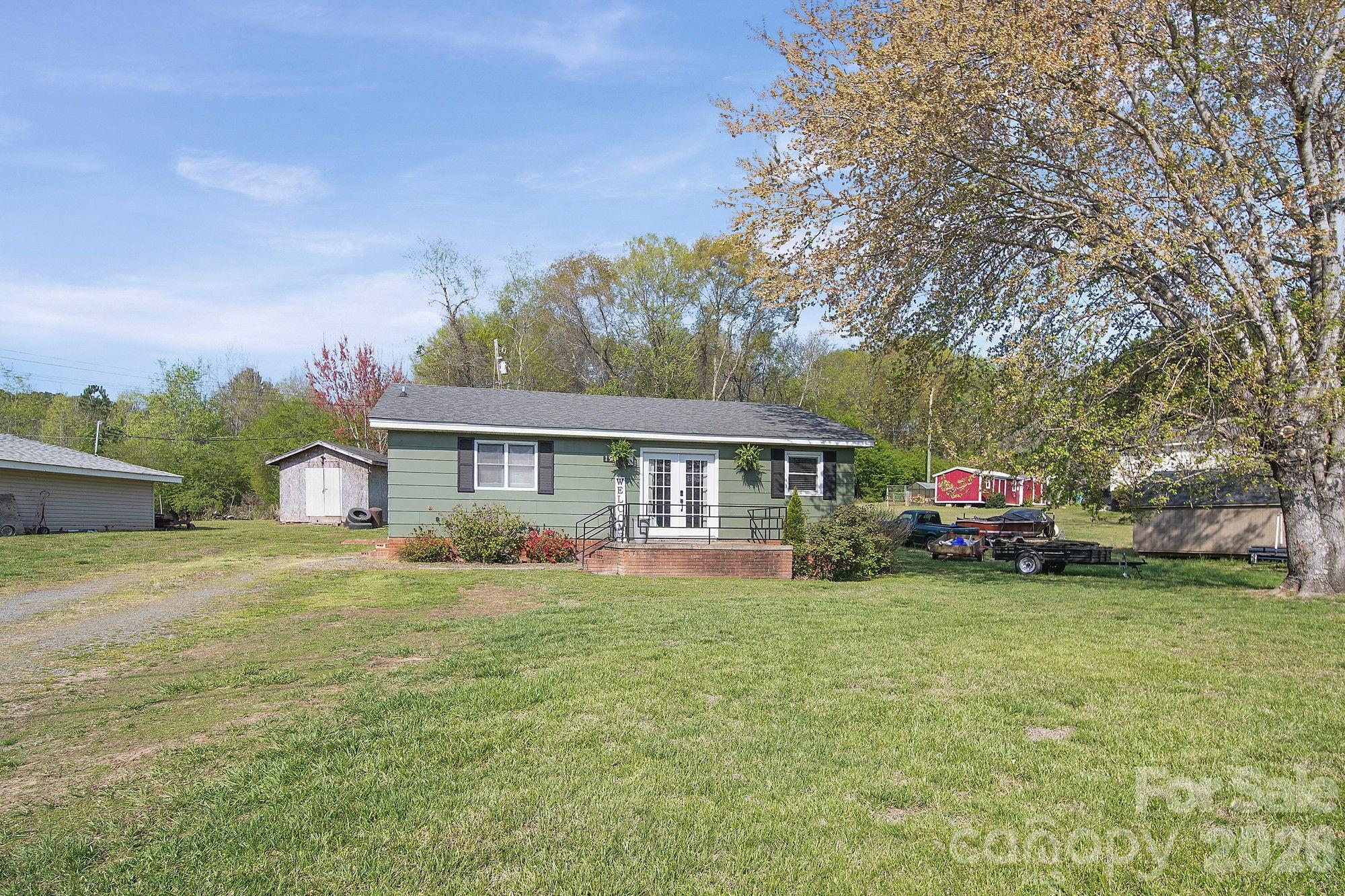 197 Vineyard Road Norwood, NC 28128 - Photo 2 of 27 a view of a house with a big yard and large trees