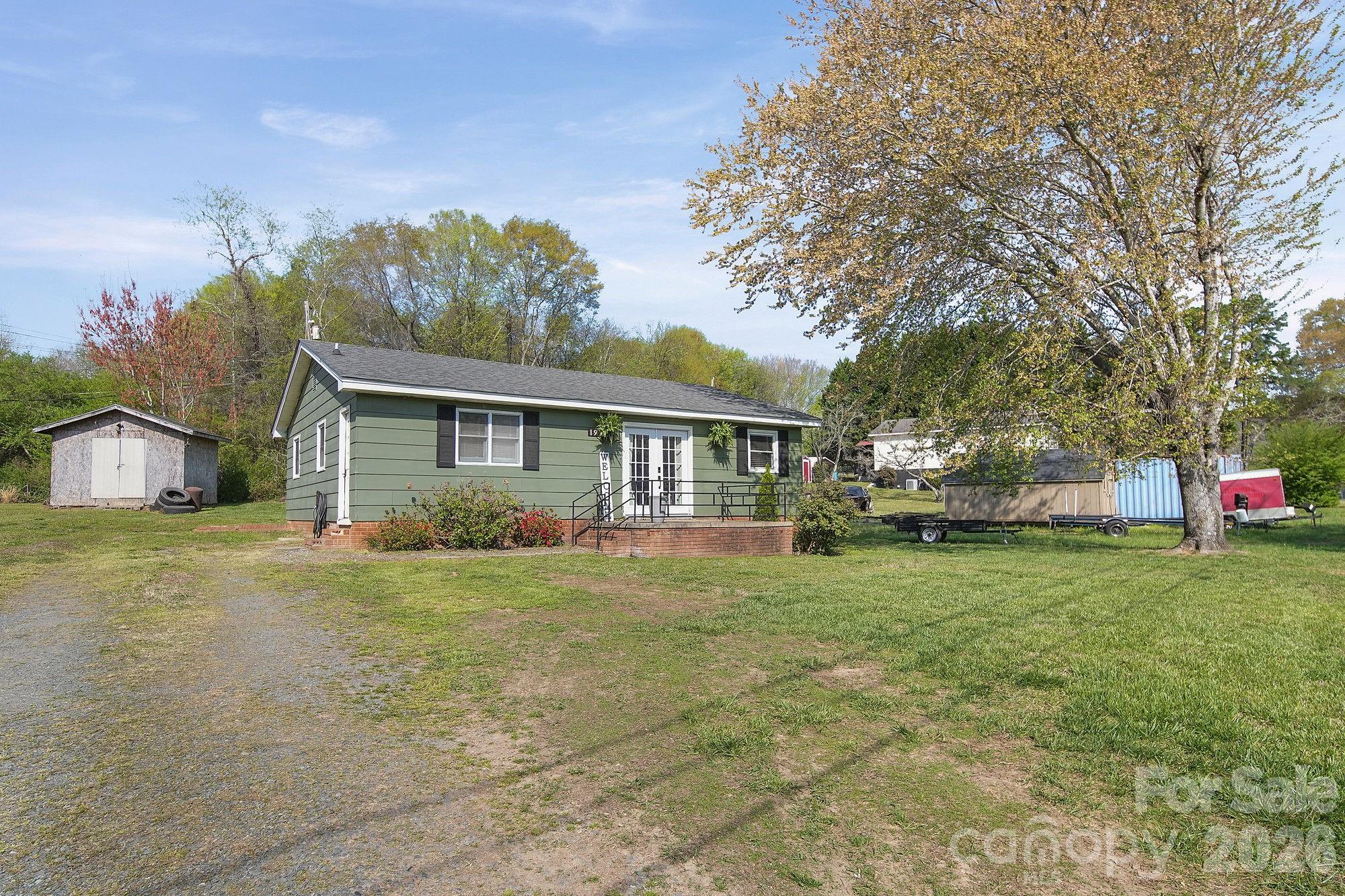 197 Vineyard Road Norwood, NC 28128 - Photo 24 of 27 a front view of a house with a yard and trees